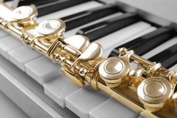 Obraz premium Golden flute musical instrument on piano keys, classical music education and performance concept, orchestra and band practice