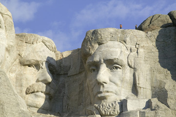 Obraz premium A park ranger and photographer standing above Abraham Lincoln at Mount Rushmore National Memorial, South Dakota