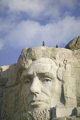 Fototapeta premium A park ranger and photographer standing above Abraham Lincoln at Mount Rushmore National Memorial, South Dakota