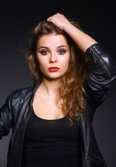 Portrait of beautiful young woman face. Isolated on dark