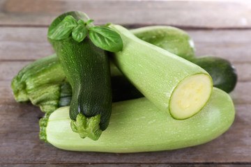 Fresh zucchini with squash and basil on wooden table close up