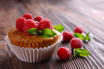 Delicious cupcake with berries and fresh mint on wooden table close up