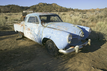 Fototapeta premium Rusted out mid-50's blue Studebaker on side of road, Route 33, near Cuyama, California