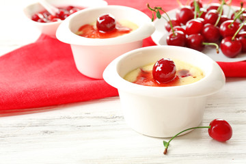 Tasty pudding with cherries on table close up