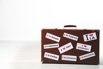 Suitcase with stickers on floor in room