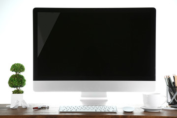 Computer on wooden table with blank white background