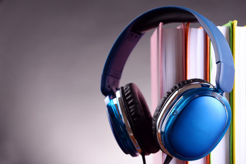 Fototapeta na wymiar Books and headphones as audio books concept on grey background