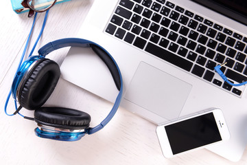 Obraz na płótnie Canvas Headphones and other devices on worktop, closeup