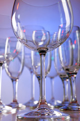 Empty wine glasses on color background