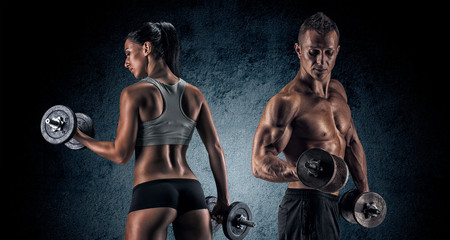 Fototapeta na wymiar Athletic man and woman with a dumbells.