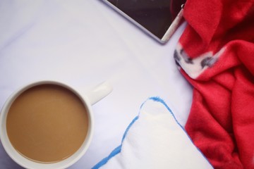 Smart phone with coffee cup on the bed