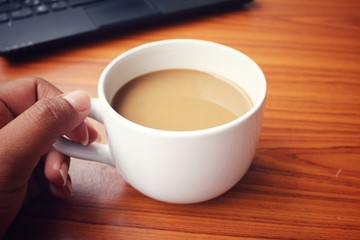 Coffee cup with notebook computer at office