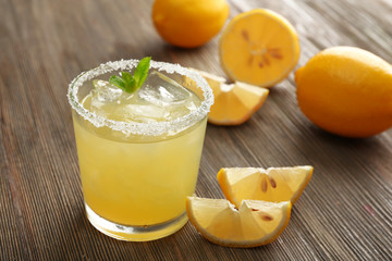 Glass of lemon juice on wooden table, closeup