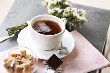 Cup of flavored coffee with chocolate on table with napkin, closeup