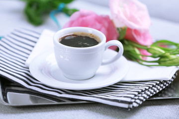 Cup of coffee with flowers on tray, closeup