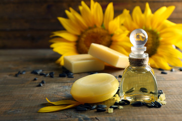 Obraz na płótnie Canvas Massage oil and spa treatments, sunflower on wooden background