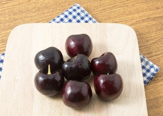 Red Plums on A Wooden Cutting Board