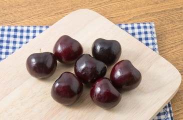 Group of Red Plums on Wooden Cutting Board