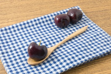 Red Plums on A Blue Checked Towel