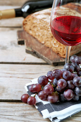 Still life of wine and bread on rustic wooden background