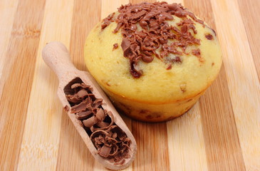 Fresh baked muffin and grated chocolate on wooden spoon