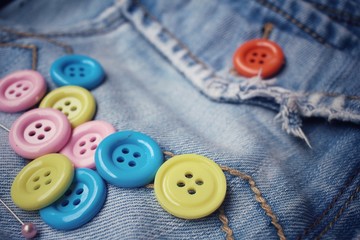 Colorful sewing buttons on jeans