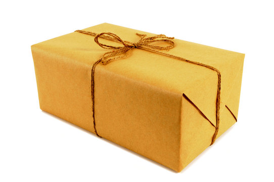 One single small brown paper package parcel tied with string isolated on white background photo