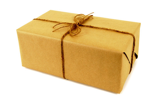 One single small brown paper package parcel tied with string isolated on white background photo