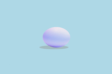 Artistic photo of an egg on light blue background.