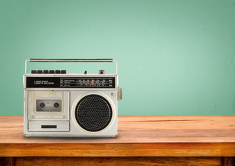 Old retro radio on table with vintage green eye light background