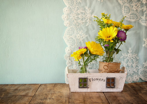 summer bouquet of flowers on the wooden table with mint background