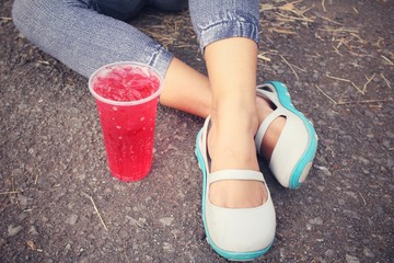 Woman and strawberry drink with shoes