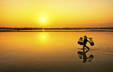 Farmer going home after a hard working day in Hon Khoi salt field, Nha Trang, Vietnam 