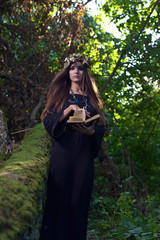 woman with book in dark forest