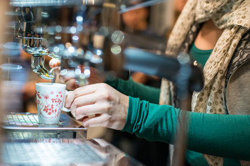 Girl at the bar prepares espresso coffee