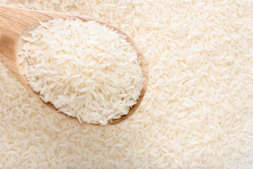 close up jasmine rice with wooden spoon on rice background.