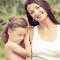 Happy mother and daughter playing in the park at the day time.