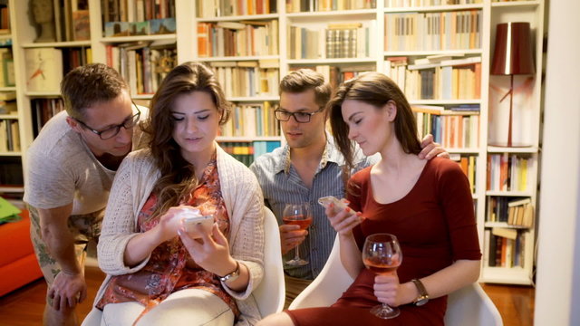 Friends sitting ath the party and using smartphones
