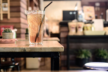 Glass of ice tea on wooden table in coffee shop