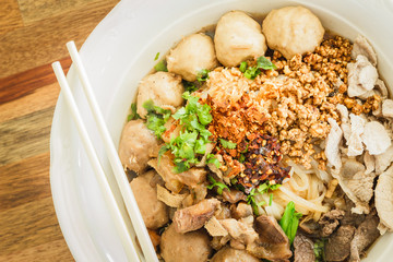 Rice noodle soup with sliced meat and meat balls.