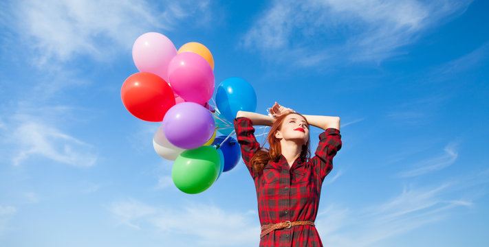 girl in plaid dress with multicolored balloons
