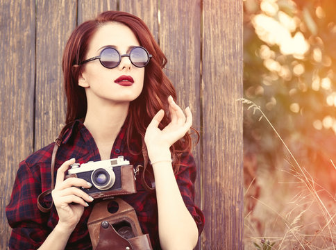 girl in plaid dress with camera and sunglasses