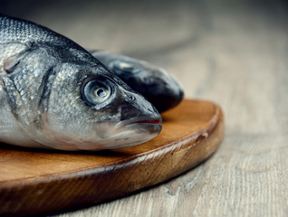 Raw seabass fish on the wooden board