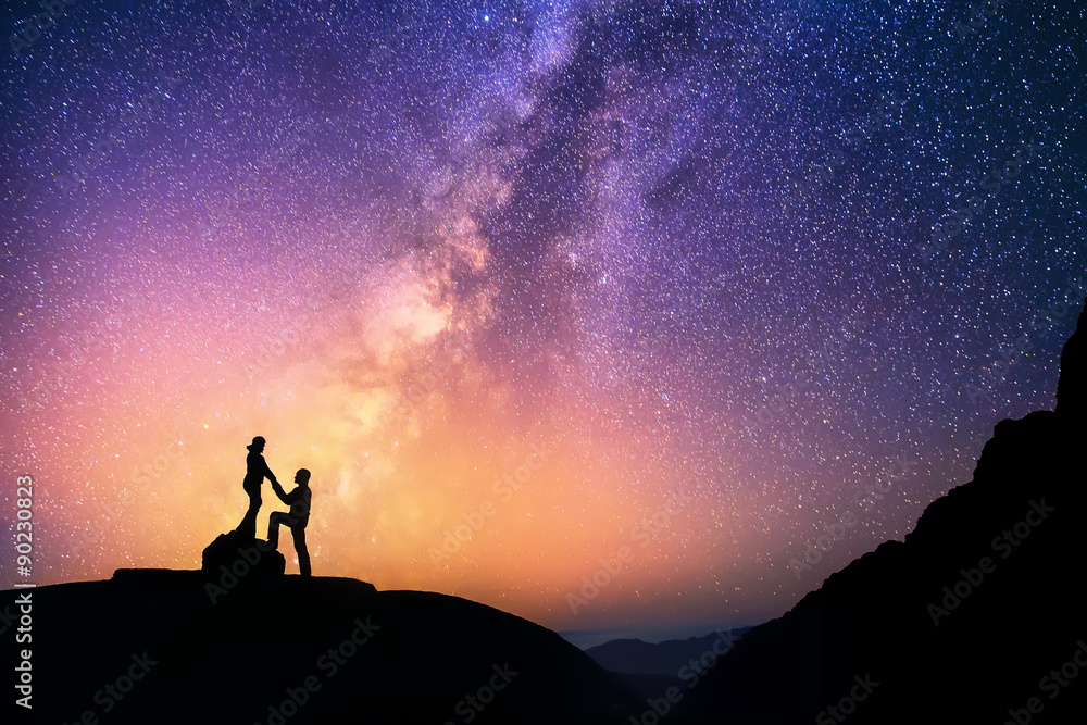 Wall mural love is in the air.romantic couple standing together holding hands in the mountains. beautiful milky