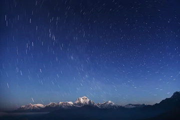 Foto op Plexiglas Dhaulagiri Night laconic landscape. Starry sky over the snowy mountains. 