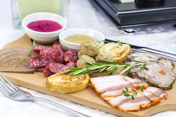 wooden dish with bacon and sausage on a white background