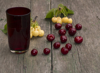 glass of juice and berry on a wooden table,