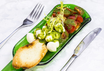 Caprese salad with tomatoes and cheese in a plate of glass