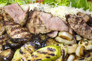 meat roasted on a grill with vegetables