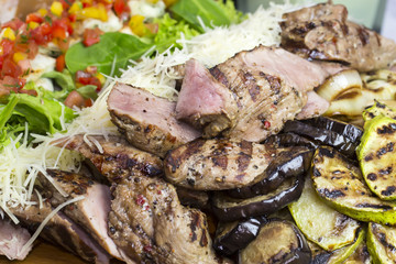 meat roasted on a grill with vegetables